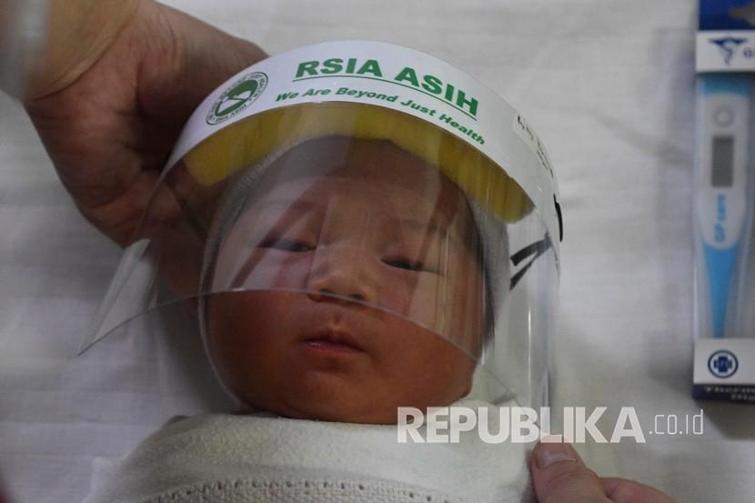 Perawat memakaikan pelindung muka atau face shield untuk bayi di RS Ibu dan Anak Asih, Jakarta, Jumat (17/4/2020). RSIA Asih memberikan perlindungan dini berupa pelindung muka atau 