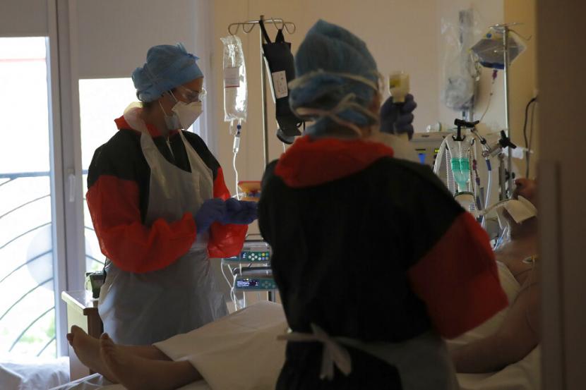 Perawat memeriksa seorang pasien Covid-19 di ruang ICU di Klinik Ambroise Pare di Neuilly-sur-Seine, dekat Paris, Perancis, Jumat (10/4). Jumlah kematian di Prancis pada Sabtu (11/4) akibat Covid-19 mencapai 14 ribu orang.