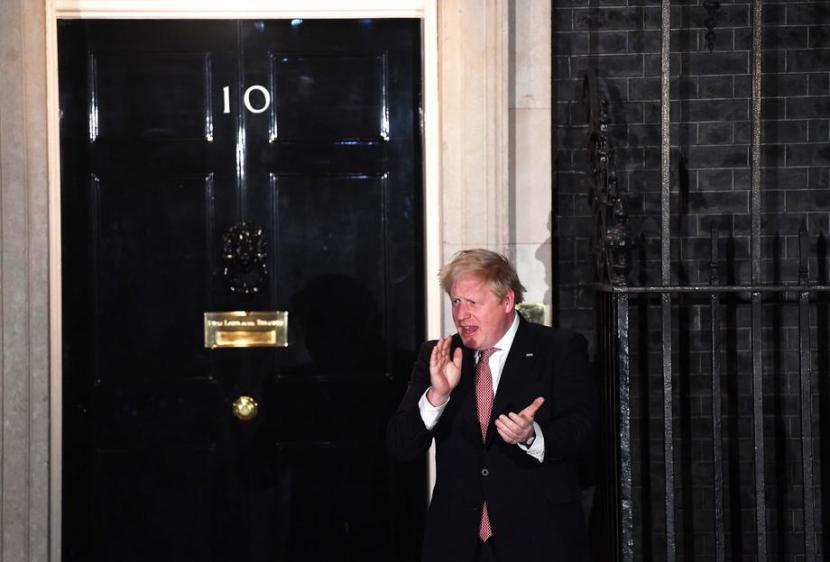 Perdana Menteri Boris Johnson bertepuk tangan dalam Clap for Carers untuk menghormati petugas medis Inggris yang melawan Corona.