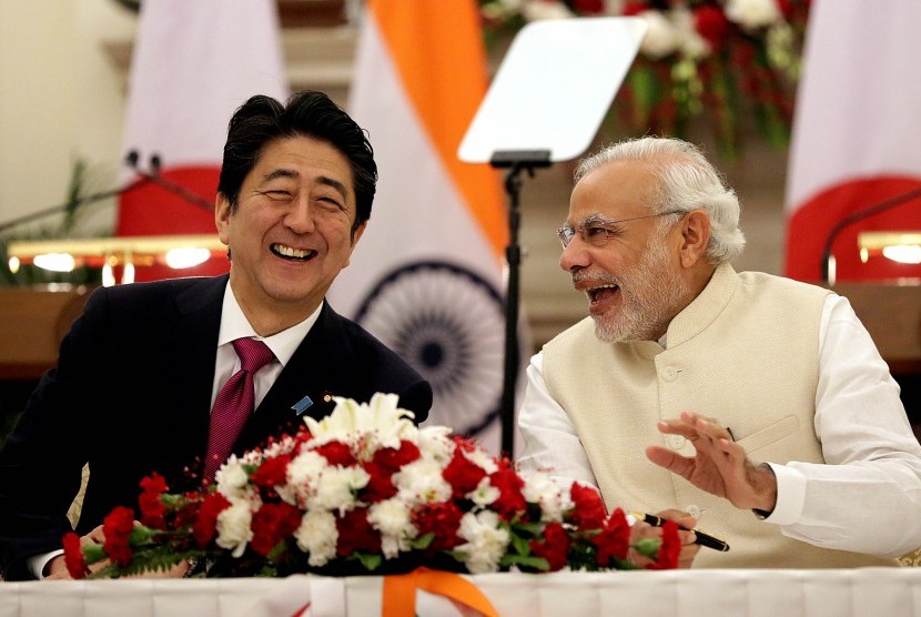 Perdana Menteri India, Narendra Modi (kanan), bersama Perdana Menteri Jepang, Shinzo Abe, bercengkerama usai menandatangani kesepakatan di Gedung Hyderabad, New Delhi, India, Sabtu (12/12). 