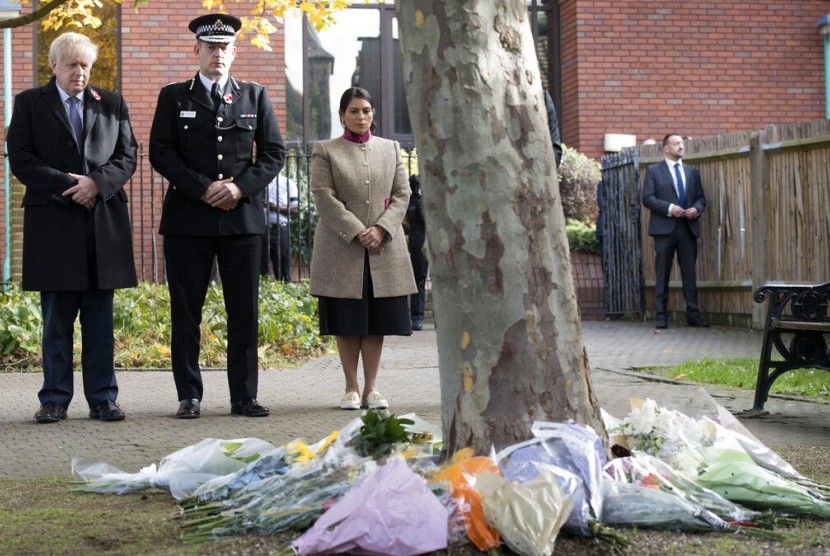 Perdana Menteri Inggris Boris Johnson (kiri) bersama Kepala Polisi Essex Ben-Julian Harrington dan Menteri Dalam Negeri Priti Patel setelah meletakkan bunga selama kunjungan ke Kantor Dewan Thurrock, Inggris, Senin (28/10). Polisi Inggris mengatakan mereka menangkap orang keempat terkait 39 mayat yang ditemukan di sebuah truk di Inggris.