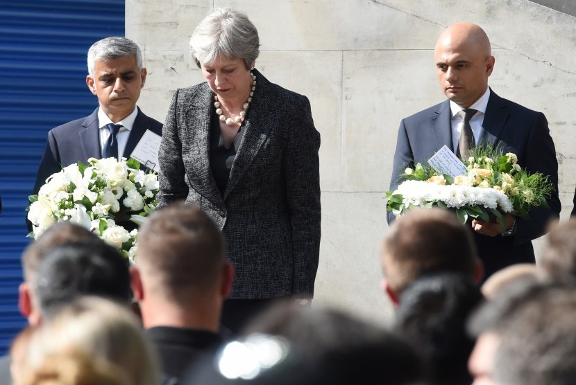 Perdana Menteri Inggris Theresa May (tengah), Wali Kota London Sadiq Khan (kiri), dan Mendagri Sajid Javid (kanan) menghening cipta satu menit di London Bridge, Ahad (3/6). 