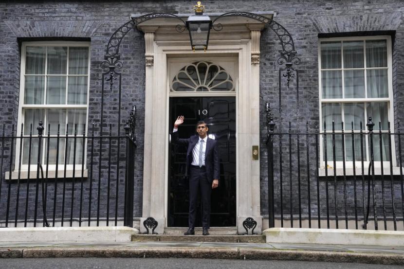 Perdana Menteri Inggris yang baru Rishi Sunak melambai setelah tiba di Downing Street di London, Selasa, 25 Oktober 2022, setelah kembali dari Istana Buckingham di mana ia secara resmi ditunjuk oleh Raja Inggris Charles III.