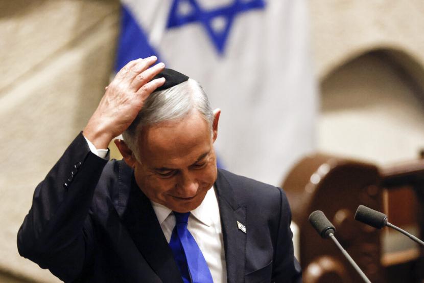 Perdana Menteri Israel yang ditunjuk Benjamin Netanyahu menyesuaikan topi tengkoraknya setelah berbicara pada sesi khusus Knesset, parlemen Israel, untuk menyetujui dan bersumpah dalam pemerintahan baru, di Yerusalem Kamis, 29 Desember 2022. Resmi Dilantik, Benjamin Netanyahu Kembali Jadi Perdana Menteri Israel