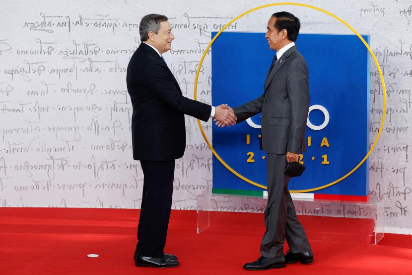 Perdana Menteri Italia Mario Draghi (kiri) menyapa Presiden Joko Widodo saat tiba di KTT para pemimpin G20 di Roma, Italia, Sabtu (30/10/2021). 