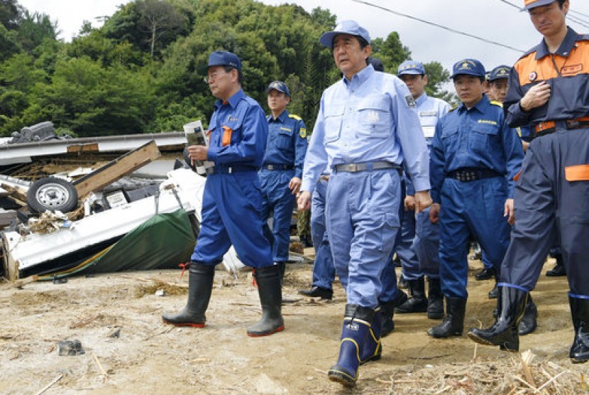 Perdana Menteri Jepang Shinzo Abe (ketiga dari kiri) memeriksa wilayah yang hancur karena banjir di Asakura, prefektur Fukuoka, Jepang, 12 Juli 2017.