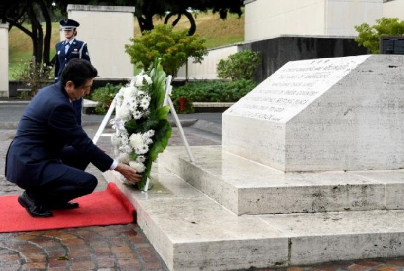  Perdana Menteri Jepang Shinzo Abe meletakkan karangan bunga di pemakaman pahlawan National Memorial Cemetery of the Pacific di Honolulu, Hawaii, Senin (26/12). Pemakaman tersebut bagi korban pengeboman di Pearl Harbour.