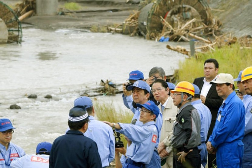 Perdana Menteri Jepang Shinzo Abe (tengah) mengunjungi wilayah barat daya di negara itu yang hancur akibat longsor dan banjir di Hita, prefektur Oita sejak satu pekan terakhir, Rabu (12/7).