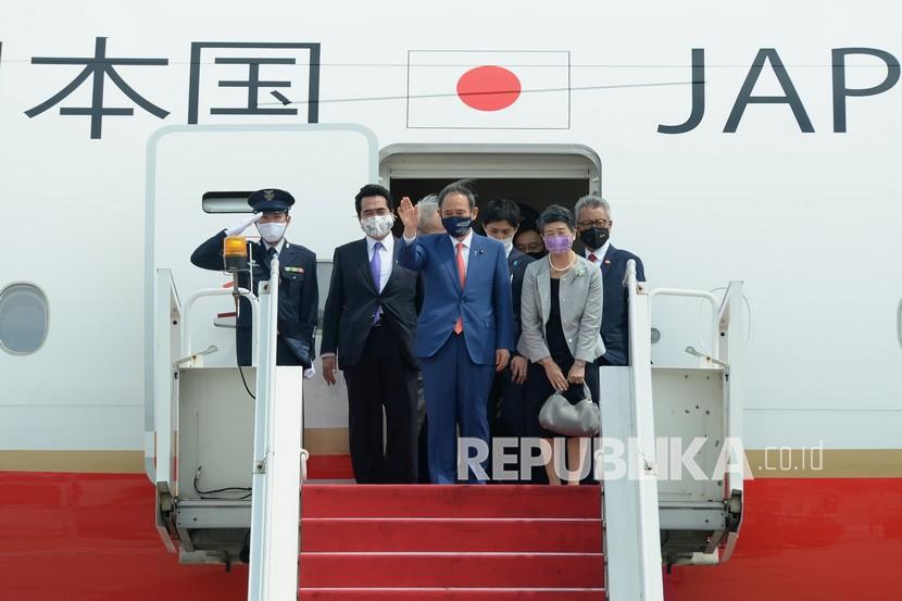 Perdana Menteri Jepang Yoshihide Suga (tengah) bersama Madam Suga Mariko (kedua kanan) melambaikan tangan setibanya di Bandara Soekarno Hatta, Tangerang, Banten, Selasa (20/10/2020). Lawatan kenegaraan tersebut dalam rangka meningkatkan hubungan bilateral antar kedua negara. 