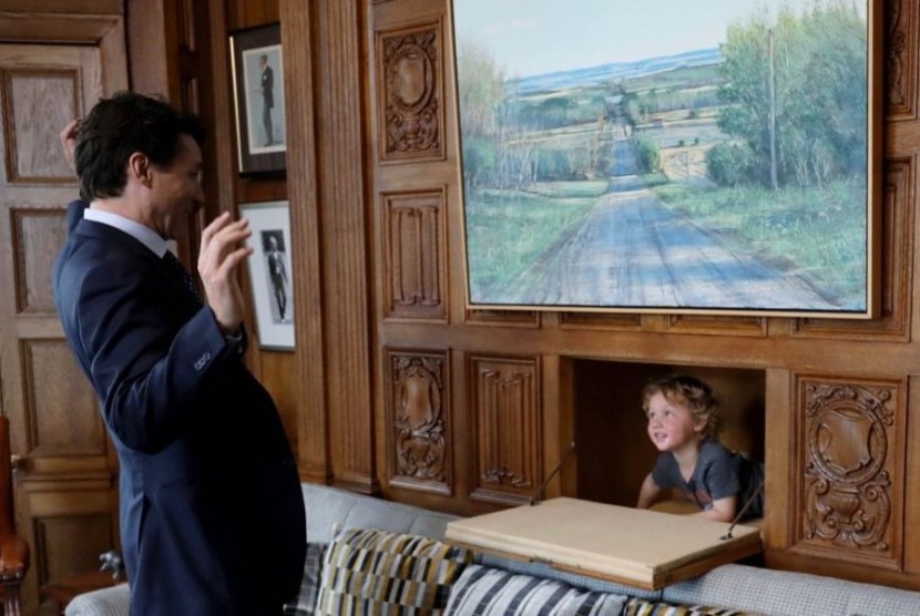Perdana Menteri Kanada Justin Trudeau sedang bermain petak umpet bersama anak bungsunya, Hadrien, di ruang kerjanya.