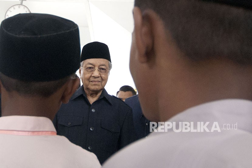 Perdana Menteri ke-7 Malaysia Tun Mahathir Mohamad (tengah) didamping jemaah berjalan seusai Salat Jumat di Masjid Negara, Kuala Lumpur, Malaysia, Jumat (11/5). 