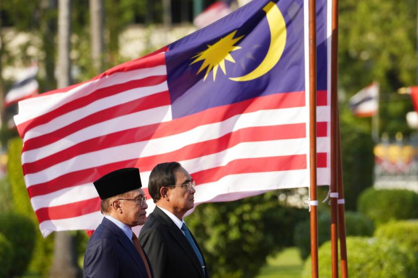 Perdana Menteri Malaysia Anwar Ibrahim, kiri, dan Perdana Menteri Thailand Prayuth Chan-ocha mendengarkan lagu kebangsaan mereka saat upacara penyambutan di Government House di Bangkok, Thailand, Kamis, 9 Februari 2023.