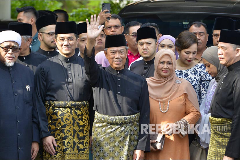 Perdana Menteri Malaysia Muhyiddin Yassin berfoto bersama keluarga dan pendukungnya sebelum mengucapkan sumpah janji sebagai perdana menteri  di Istana Negara Kuala Lumpur. ((Johnshen Lee/AP)