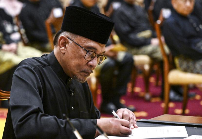  Perdana Menteri Malaysia Anwar Ibrahim menandatangani dokumen setelah mengambil sumpah dalam upacara pelantikan di Istana Nasional di Kuala Lumpur, Malaysia, Kamis (24/11/2022).