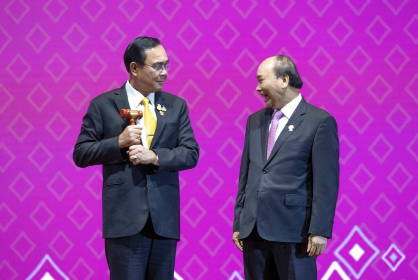 Perdana Menteri Thailand Prayut Chan-o-cha menyerahkan sebuah palu kayu kepada Perdana Menteri Nguyen Xuan Puc, yang menyimbolkan pergiliran keketuaan ASEAN dari Thailand ke Vietnam.