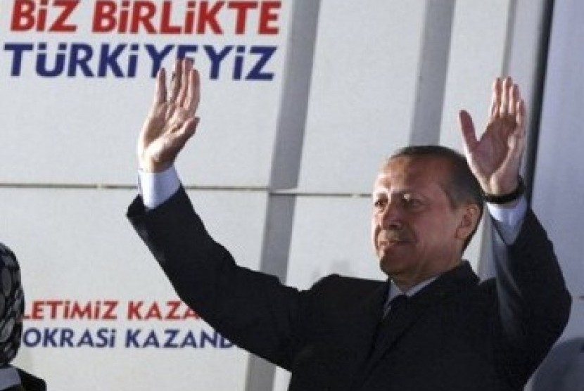 Perdana Menteri (kini Presiden) Turki Recep Tayyip Erdogan melambaikan tangan ke arah pendukungnya di depan kantor pusat AKP di Ankara, Turki, Ahad (12/6).