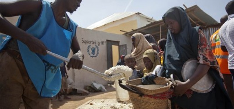 Perempuan dan anak Somalia baris mengantre makan di kamp pengungsian di Mogadishu, Somalia, Kamis (19/1). 