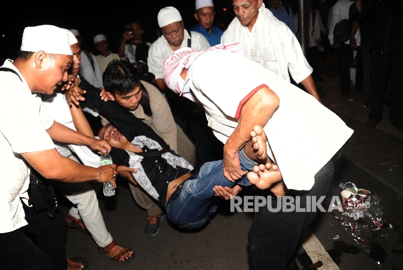  Perempuan digotong saat terkena gas air mata saat melakukan aksi di depan istana negara, Jakarta, Jumat (4/11) malam.