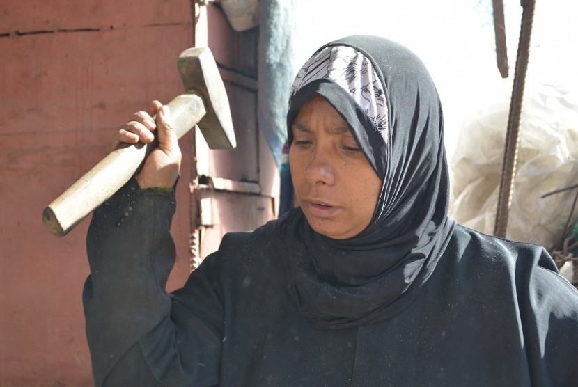 Perempuan Gaza pencari nafkah Ayesha Ibrahim (37 tahun) dan putrinya (15) bergiliran menempa besi panas dengan palu.