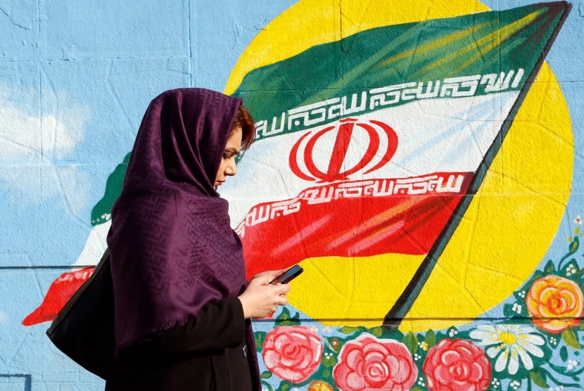 Perempuan Iran sedang melintas di salah satu sudut kota.