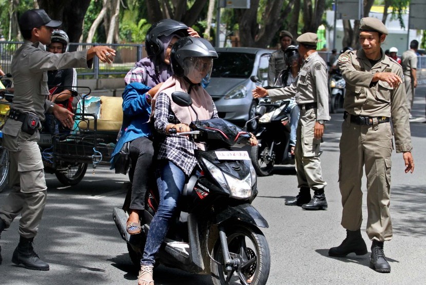 Perempuan memakai celana ketat terjaring razia Polisi Syariat Islam atau Wilayatul Hisbah dibantu Satpol PP dan aparat TNI/Polri saat razia penegakkan syariat Islam di Lhokseumawe, Provinsi Aceh. Selasa (15/9).