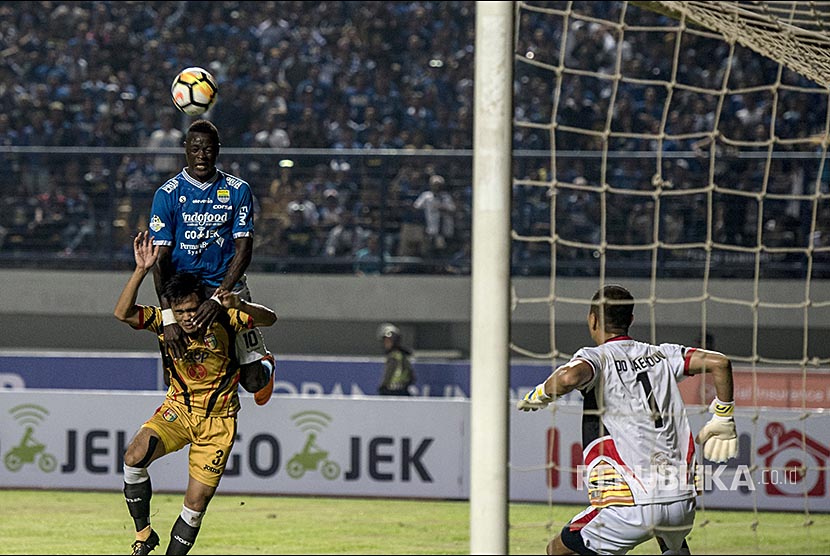 Striker Persib Ezechiel Ndouasel (atas) berusaha menyundul bola melewati pesepak bola Mitra Kukar Wiganda Pradika (bawah) saat laga lanjutan Liga 1 2018 di Stadion Gelora Bandung Lautan Api, Bandung, Jawa Barat. Minggu (8/4). 