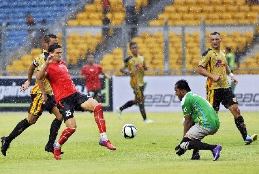 Persija Pedro Javier (tengah) dihadang Penjaga gawang Mitra Kukar Syamsidar (kanan)