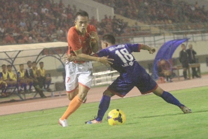 Persis Solo, Tinton (kiri) mencoba melewati hadangan pemain Persiku Kudus Agus Riyanto pada laga pra musim di Stadion Manahan, Solo, Jateng, Kamis (20/2) malam. 