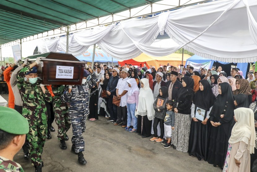 Personel Basarnas dibantu TNI dan Polri mengusung peti jenazah korban jatuhnya pesawat Lion Air JT 610 setibanya di terminal cargo Bandara Depati Amir, Pangkalpinang, Kepulauan Bangka Belitung, Rabu (7/11/2018). 