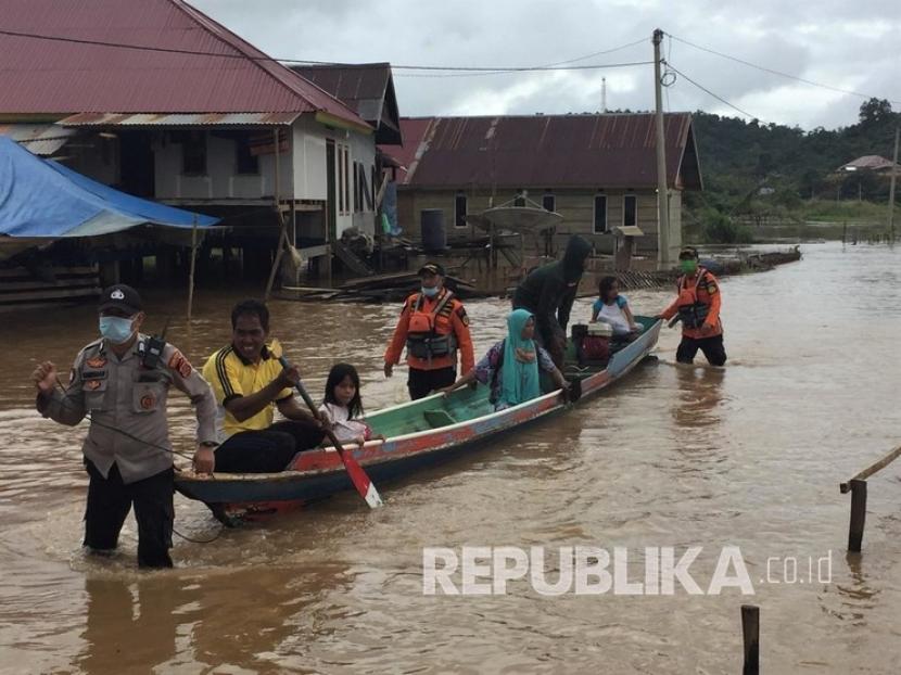 Personel Basarnas Kendari dan kepolisian membantu warga mengungsi dari lokasi banjir dengan sampan di Desa Puwanggudu, Kecamatan Asera, Konawe Utara, Sulawesi Tenggara, Sabtu (20/6/2020). Akibat intensitas hujan tinggi di wilayah tersebut menyebabkan lima desa di Kecamatan Andowia dan satu desa di Kecamatan Asera terendam banjir. 