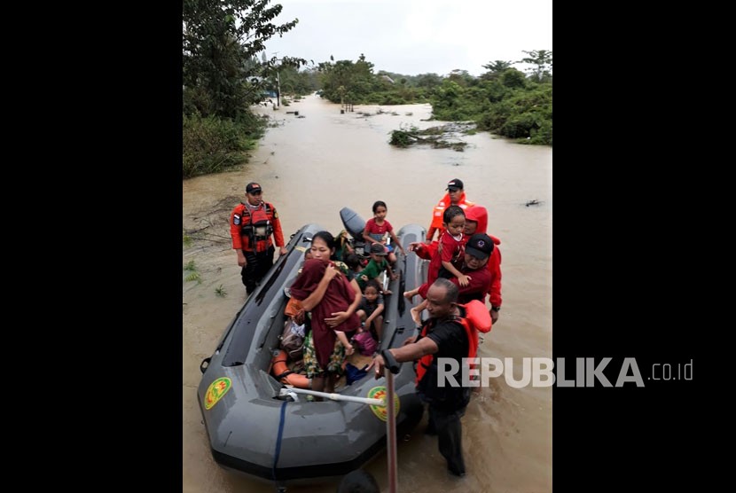 Personel Basarnas Kendari mengevakuasi korban banjir bandang di wilayah terisolir yang terjebak di atap rumahnya di Desa Tanggawuna, Konawe, Sulawesi Tenggara, Minggu (9/6/2019). 