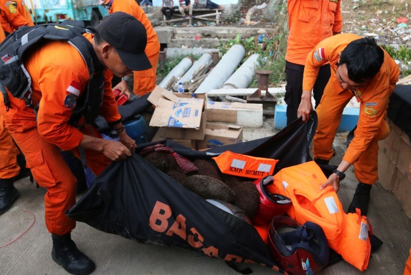 Personel Basarnas membawa sejumlah barang yang diduga milik penumpang KM Sinar Bangun di posko Pelabuhan Tigaras, Danau Toba, Simalungun, Sumatera Utara, Senin (25/6).