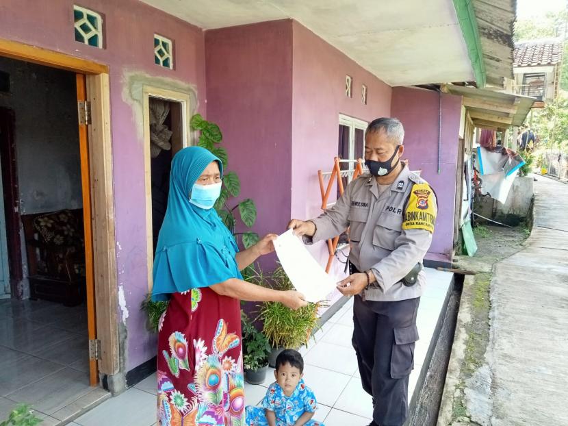 Personel Bhabinkamtibmas Polres Sumedang mendatangi rumah-rumah warga menyerahkan undangan vaksinasi Covid-19 dosis dua dan tiga