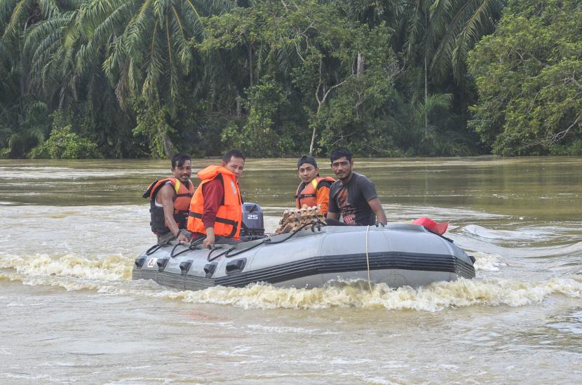 Personel BPBD Aceh Timur membawa bantuan logistik untuk korban banjir menggunakan perahu karet di Desa Cek Mbon, Kecamatan Pereulak, Kabupaten Aceh Timur, Aceh, Senin (3/1/2021). Data dari Badan Penanggulangan Bencana Daerah (BPBD) Aceh Timur mencatat banjir yang merendam 17 Kecamatan di daerah tersebut mengakibatkan 13.715 jiwa terdampak. 