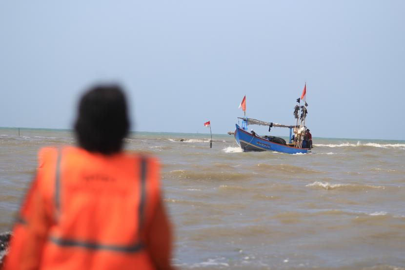 Personel BPBD mengawasi perahu saat pencarian nelayan yang tenggelam di Indramayu, Jawa Barat.