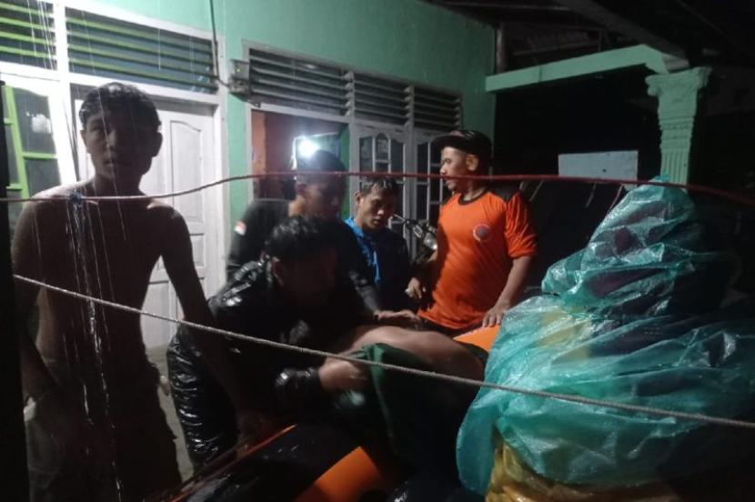 Personel BPBD Padang mengevakuasi warga korban banjir di Jalan Gajah Mada Dalam, Alai Parak Kopi, Padang, Sumatera Barat, Jumat (8/3/2024) dini hari. 