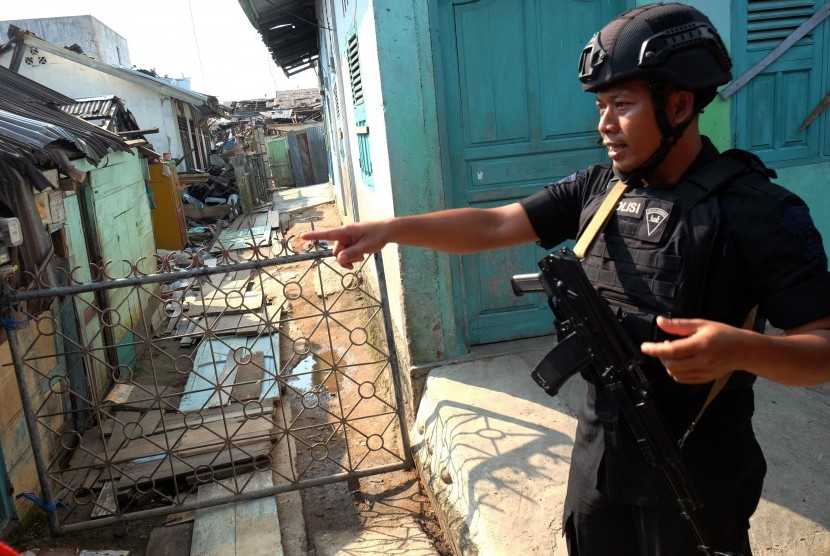 Personel Brimob berjaga di dekat lokasi rumah terduga teroris dan juga rumah warga yang rusak akibat ledakan bom bunuh diri yang dilakukan Solimah istri terduga teroris Husain alias Abu Hamzah, di Kecamatan Sibolga Sambas, Sibolga, Sumatra Utara. 