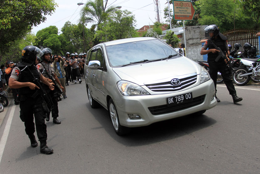  Personel Brimob bersiaga di samping mobil yang membawa Walikota Medan non aktif Rahudman Harahap ketika proses eksekusi yang dilakukan tim Kejaksaan Tinggi Sumut, di Medan, Selasa (15/4). 