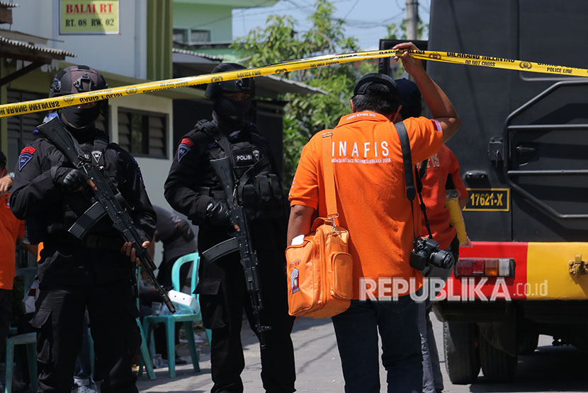 Personel Brimob bersiaga saat dilakukannya penggeledahan oleh Tim Densus 88 di kediaman terduga pelaku bom bunuh diri Polrestabes Surabaya, di Tambak Medokan Ayu, Surabaya, Jawa Timur, Selasa (15/5). 