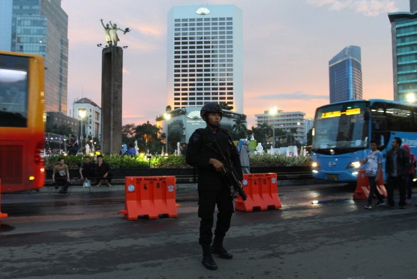 Personel Brimob melakukan pengamanan di kawasan Bundaran HI, Jakarta, Minggu (31/12). Pengamanan malam pergantian tahun itu guna memberikan kenyamanan kepada masyarakat dan memastikan keamanannya.