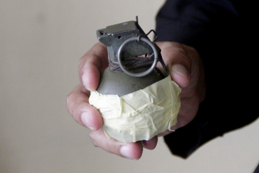 Personel Brimob menunjukkan barang bukti berupa tas dan satu buah granat aktif.