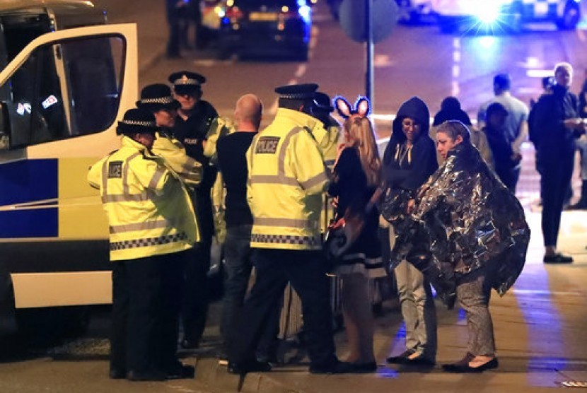 Personel darurat berbicara kepada warga di luar Manchester Arena usai laporan adanya ledakan saat di dalam tempat konser Ariana Grande di Manchester, Inggris, Senin, 22 Mei 2017.