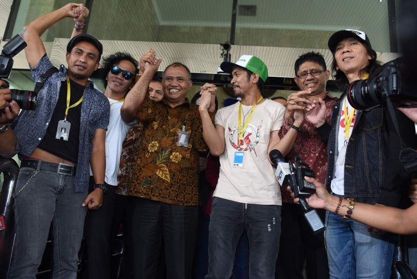 Personel grup band Slank bergandengan tangan dengan Ketua KPK Agus Rahardjo (ketiga kiri) sebelum menggelar konser di halaman Gedung KPK, Jakarta, Senin (22/2)