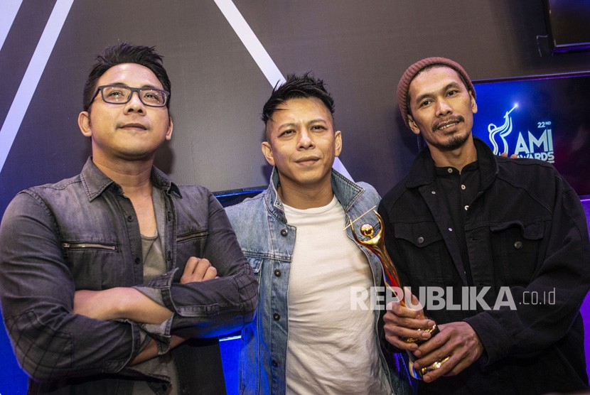 Personel grup musik Noah, Ariel (tengah), Lukman (kanan), dan David (kiri), berpose dengan memegang piala penghargaan pada Malam Anugerah Musik Indonesia (AMI) 2019 di Jakarta, Rabu (27/11/2019). Noah menganggap vlog dapat menjaga kedekatan dengan penggemarnya.