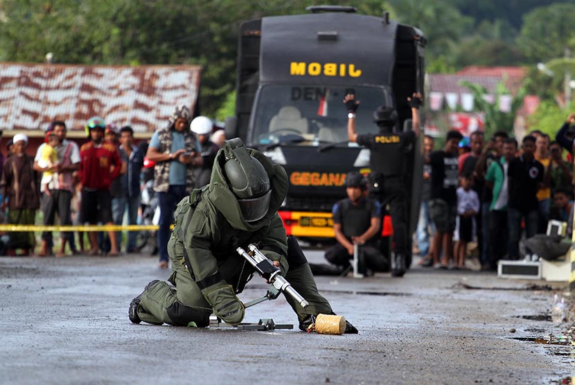 Personel Jihandak Brimob JIBOM Detasemen B Polda Aceh menempatkan alat untuk meledakkan benda yang diduga bom, saat teror bom di Desa Kandang, Muara Dua, Lhokseumawe, Provinsi Aceh, Jumat (20/1). 