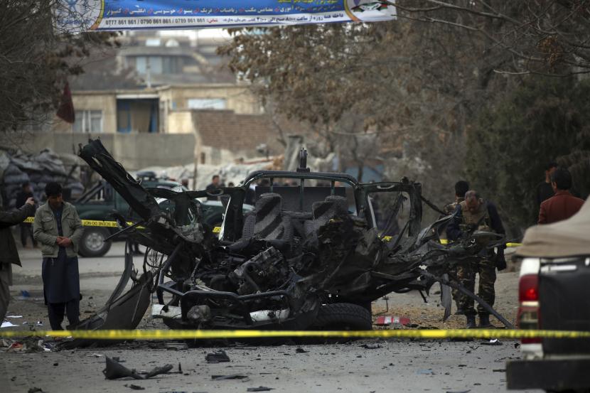 Personel keamanan Afghanistan mengeluarkan kendaraan yang rusak dari lokasi serangan bom di Kabul, Afghanistan, Sabtu, 20 Februari 2021. Tiga ledakan terpisah di ibu kota Kabul pada Sabtu menewaskan dan melukai banyak orang, kata seorang pejabat Afghanistan. 