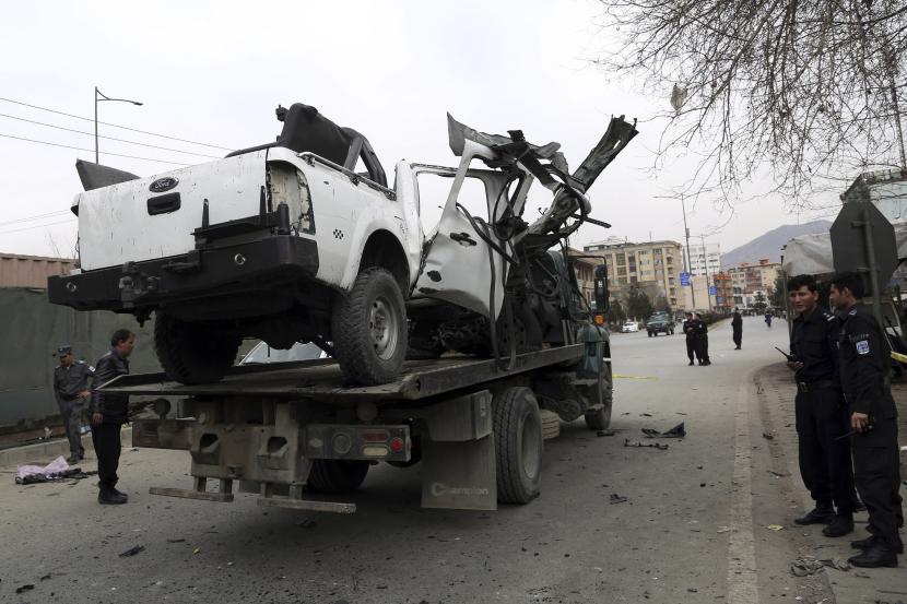  Personel keamanan Afghanistan mengeluarkan kendaraan yang rusak dari lokasi serangan bom di Kabul, Afghanistan, Sabtu, 20 Februari 2021. Tiga ledakan terpisah di ibu kota Kabul pada Sabtu menewaskan dan melukai banyak orang, kata seorang pejabat Afghanistan.