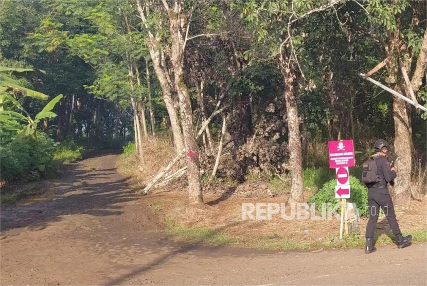 Personel keamanan melakukan pengamanan di jalan menuju kawasan lokasi peledakan amunisi afkir di Desa Sagara, Kecamatan Cibalong, Kabupaten Garut, Jawa Barat, Selasa (13/5/2025).