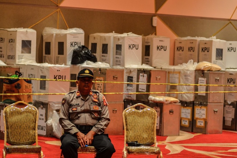 Personel kepolisian berjaga di dekat kotak suara hasil rekapitulasi perolehan suara saat berlangsungya Rapat Pleno Rekapitulasi Penghitungan Perolehan Suara Tingkat Kota Tasikmalaya di Jawa Barat, Sabtu (4/5/2019). 