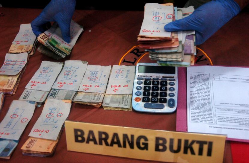Personel kepolisian menata barang bukti judi online dan judi manual saat rilis kasus di Polres Pemalang, Jawa Tengah, Jumat (19/8/2022).